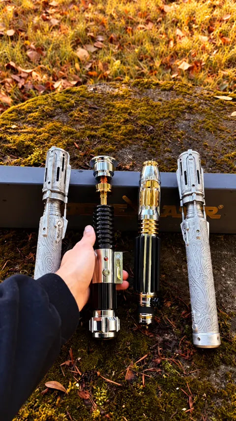 Quatre poignées de sabres laser présentées ensemble sur un support
